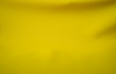 Close-up of beautiful and luxurious yellow silk texture, waves (blurred or blurry)
