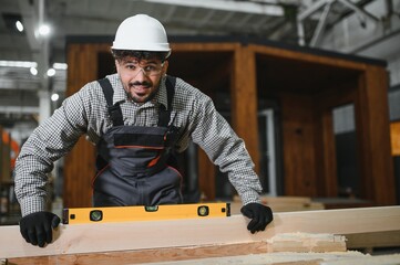 Arab carpenter using spirit level on wooden plank in workshop
