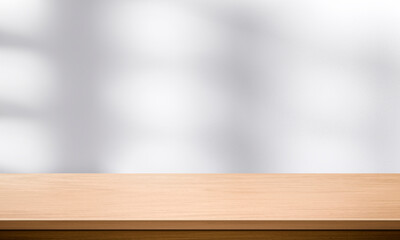 Wood table top and blurred wall shadow leaves window background can used for display or montage your products