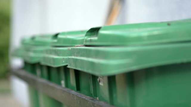 A green trash can with a lid on top
