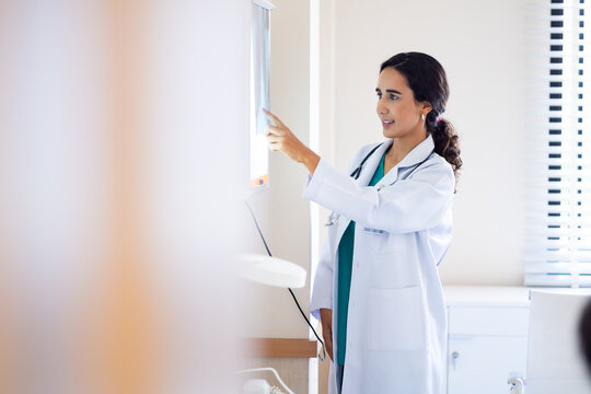 x-ray, Radiologist : Hispanic latin female doctor looking at x-ray film.  ct scan, mri, Woman radiologist checking investigating patient`s lungs on image. coronavirus treatment