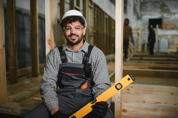 Skilled worker building modular house in workshop