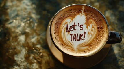 Close-up overhead view of coffee cup featuring "Let's Talk!" message written in latte art foam