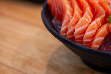 High angle view of salmon seafood in black bowl on table