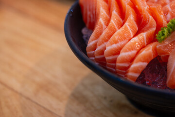 High angle view of salmon seafood in black bowl on table