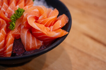 High angle view of salmon seafood in black bowl on table