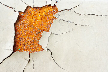 Walls whose paint is peeling off because they are old and exposed to heat and rain. The wall color is beige. Abstract background texture from walls with damaged paint.