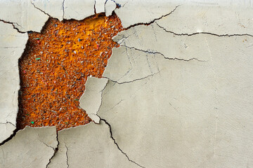 Walls whose paint is peeling off because they are old and exposed to heat and rain. The wall color is beige. Abstract background texture from walls with damaged paint.