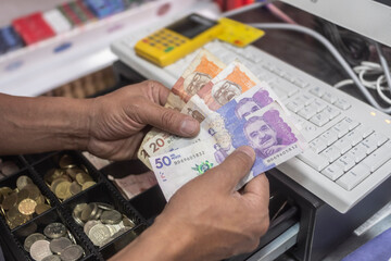 Colombian money, pesos, hand, cash register, - Concept of economy