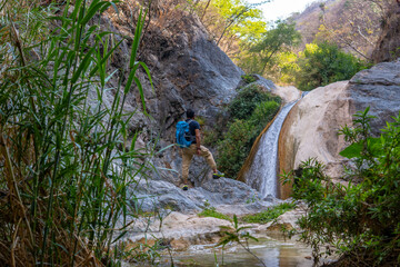 Hiker admiring the la magdalena waterfalls in tlatlauquitepec, puebla, mexico