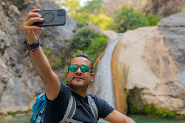 Tourist taking a selfie at la magdalena waterfalls in tlatlauquitepec, puebla, mexico
