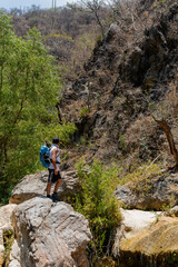 Hiker contemplating the landscape at cascadas la magdalena in tlatlauquitepec, puebla, mexico