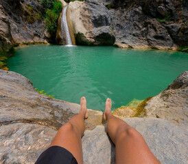Tourist relaxing by the turquoise pond with waterfall in puebla, mexico