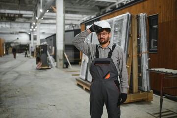 Arab construction worker adjusting hardhat in modular house factory