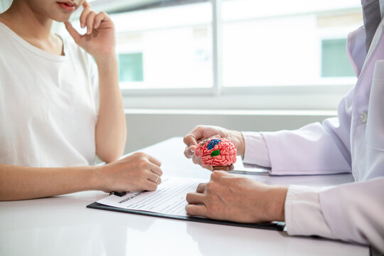 doctor is asking about patient information and symptoms to diagnose brain diseases before consulting patient and diagnosing correct treatment. doctor is consulting patient about brain problems.