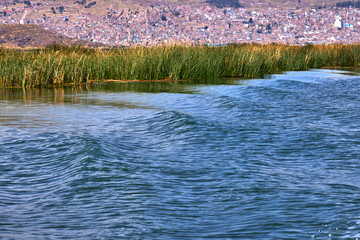 Sailing into the calm waters of Lake Titicaca’s channel stretch, with Puno city in the background.