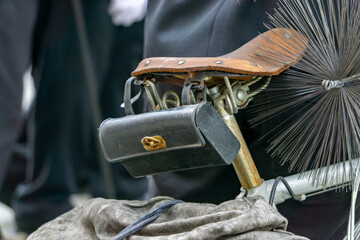 Traditional chimney sweep equipment mounted on a bicycle – visible chimney brush, leather seat, and tool bag. An unusual means of transport for a chimney sweep.