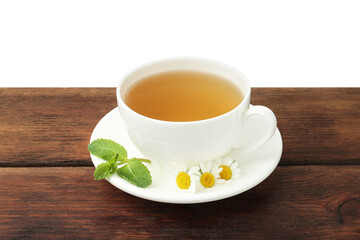 Delicious chamomile tea in cup, fresh flowers and mint on wooden table against white background