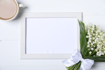 Bouquet of beautiful lily-of-the-valley flowers, coffee and blank frame on white wooden background, flat lay. Space for text