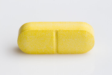 yellow medical pills on white background