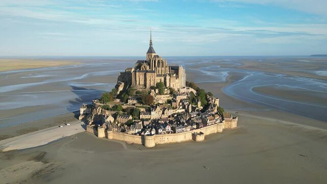 Drone view of Mont-Saint-Michel Abbey nestled in expansive tidal landscape with rural land in France