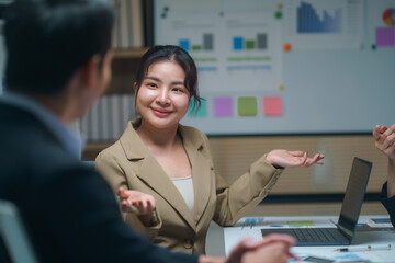 Asian businesswoman explaining new project to colleagues during business meeting in modern office