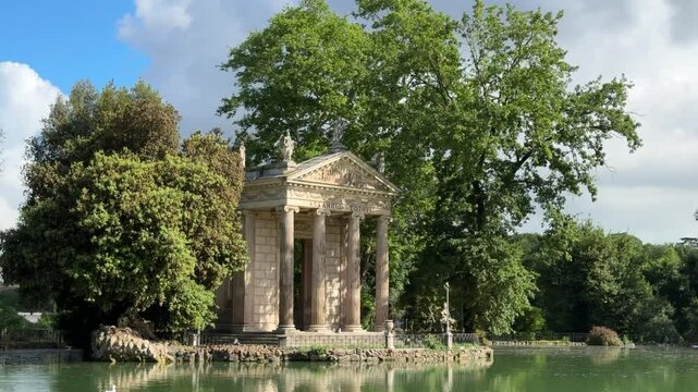 The Temple of Aesculapius in Rome, a small ancient temple dedicated to the god of medicine, nestled in the picturesque Villa Borghese gardens by a peaceful lake.

