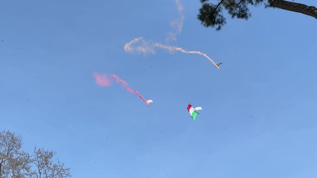 Parachutists with the Italian flag performing a breathtaking aerial display, showcasing national pride and skill against a clear sky backdrop.

