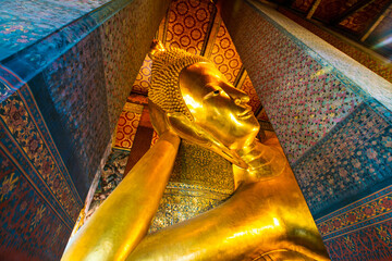 Golden big reclining buddhist statue in temple
