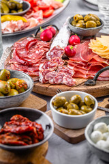 Assorted appetizers and antipasti platters on wooden tray, catering concept with meats and cheese