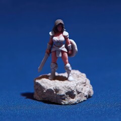3D display figure of armored female warrior in battle pose on detailed terrain base