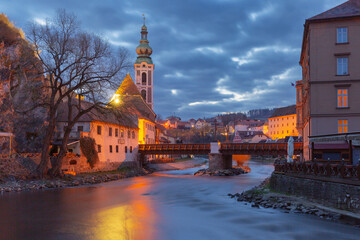 Naklejka premium Historic buildings and tower at sunrise in Cesky Krumlov Czech Republic with morning light over the old town