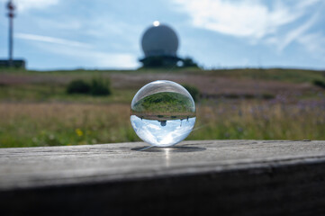 A glass ball on wood with reflection of a radar dome - radome