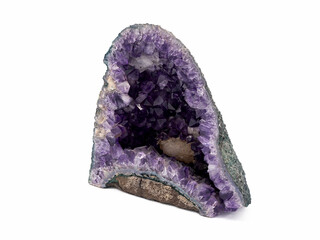 amethyst geode displaying vibrant purple crystals and rugged outer rock shell against a white...