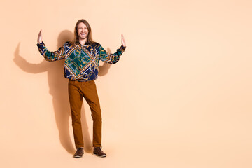 Portrait of a stylish young man posing with cheerful demeanor and a vibrant outfit against a beige background for lifestyle imagery.