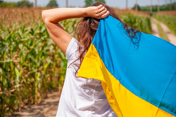 Flag of Ukraine. Independence day. Ukrainian flag day. August 24th. Free woman patriot. Carefree girl with Ukrainian flag in maize field. Independence day of Ukraine. Freedom symbolic