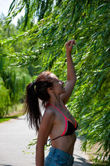 Outdoor lifestyle in nature. Willow tree branches in wind. Woman among willow tree branch in wind...