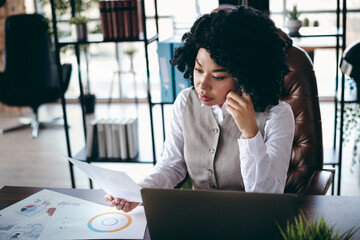 Skilled busy businesswoman reviewing documents in an office environment