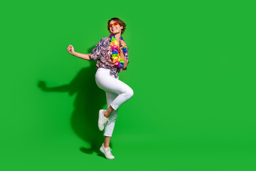 Full size photo of overjoyed cute girl wear print shirt necklace dance look at discount empty space isolated on green color background