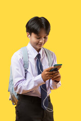 Teenage girl student with short hair using smart phone and listening to music from earphones while...