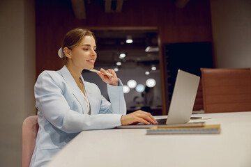 A focused businesswoman works diligently at her stylish desk, showcasing high productivity and...