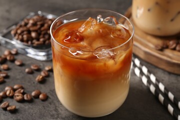 Tasty iced coffee and beans on grey table, closeup