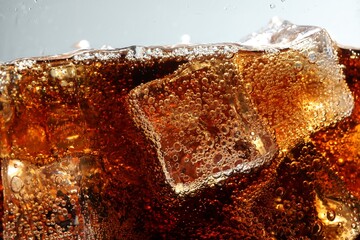 Refreshing cola with ice cubes against light grey background, closeup