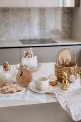 Happy Easter decor on the table in the kitchen. Eggs, Easter cake, sweets, flowers, basket and candles. Easter decoration traditions