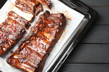 Delicious spare ribs on grey wooden table, top view
