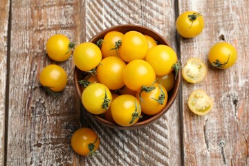 Many fresh yellow tomatoes on wooden table, flat lay