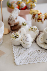 Happy Easter decor on the table in the kitchen. Eggs, Easter cake, sweets, flowers, basket and candles. Easter decoration traditions