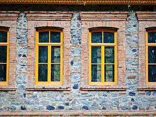 Yellow windows decorating a stone and brick wall creating a colorful pattern