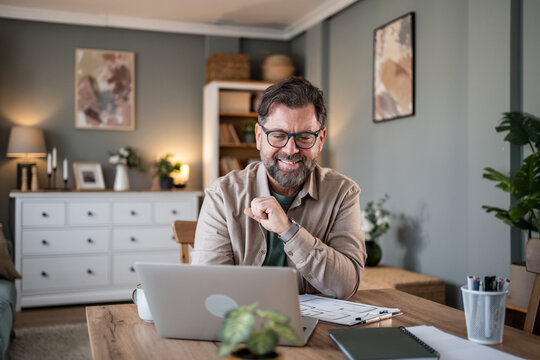 Smiling architect working from home using laptop for video call