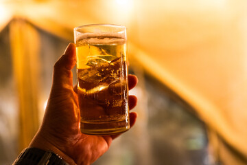 Refreshing golden beer in hand at night scene